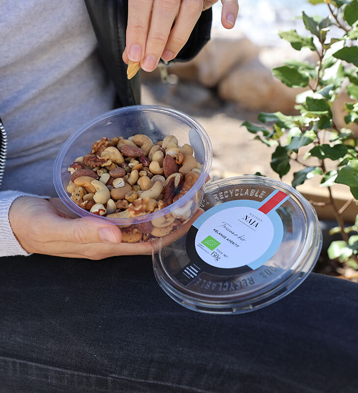 a person holding a bowl of nuts