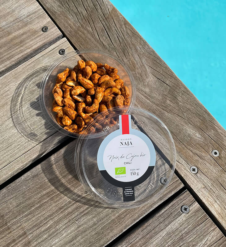 a bowl of nuts on a wood surface